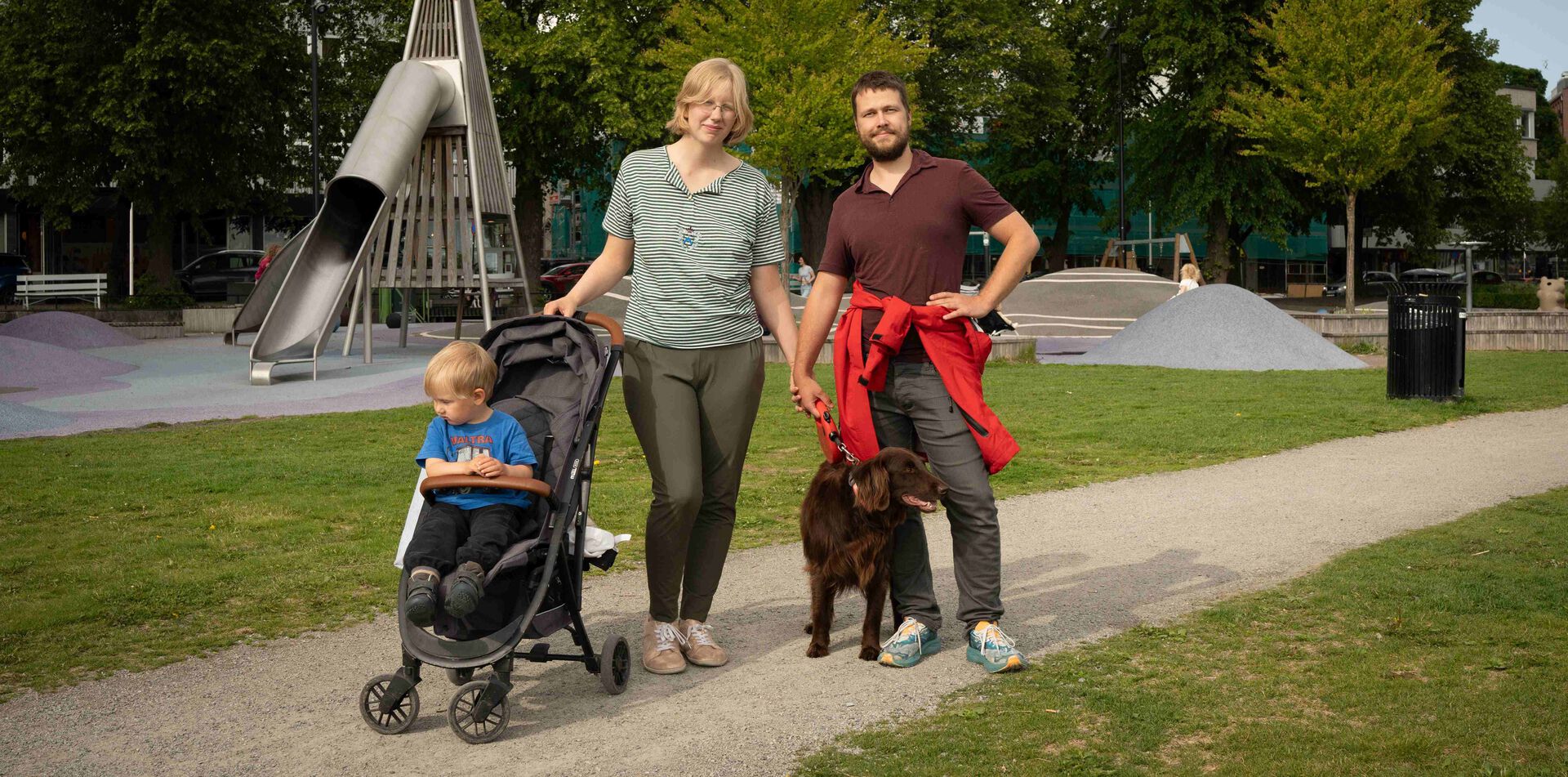 Familien Allas, inkludert hund, går tur på lekeplassen i Hamar sentrum.
