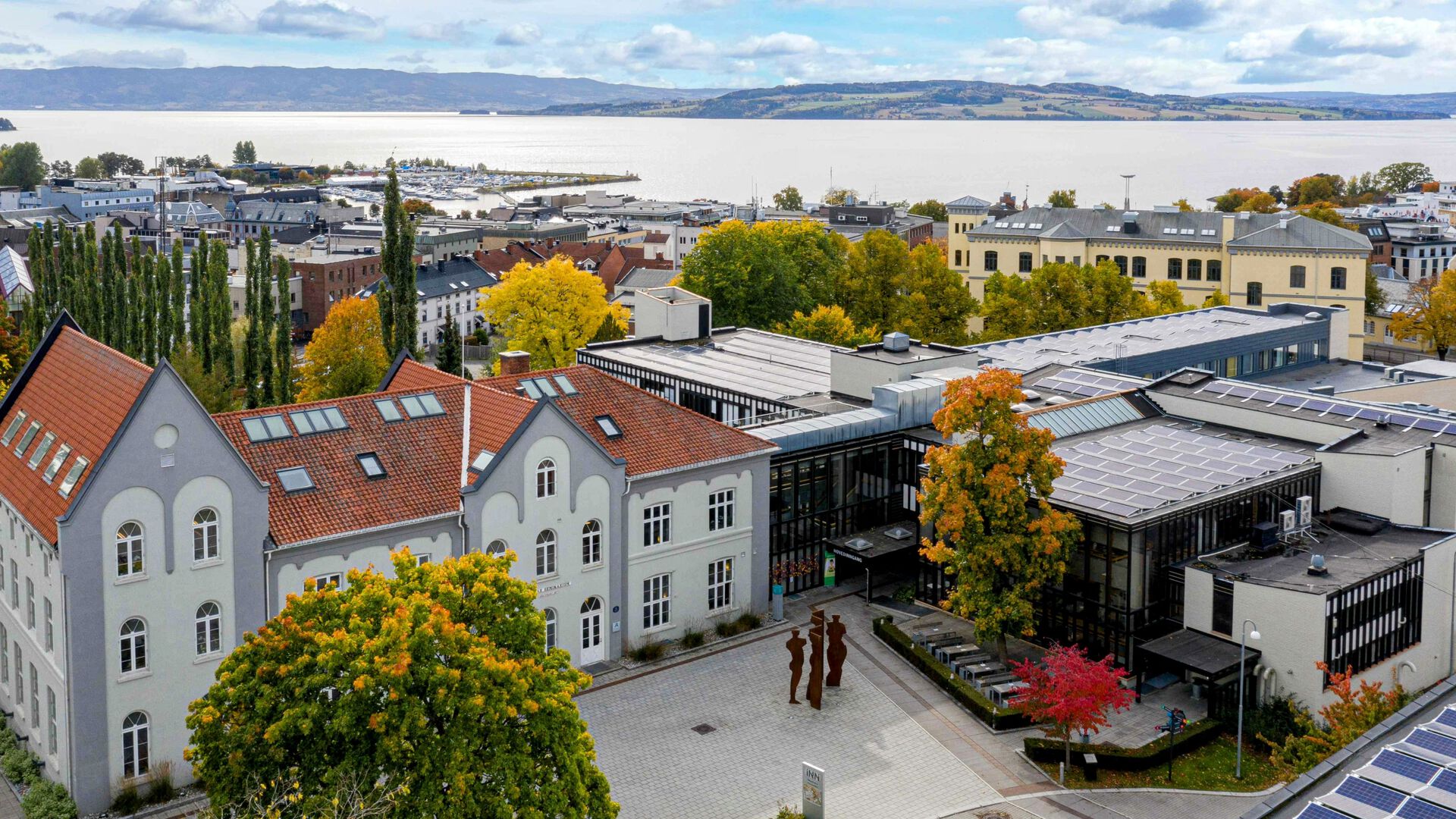Dronebilde over Universitetet i Innlandets campus på Hamar med byen og Mjøsa i bakgrunnen