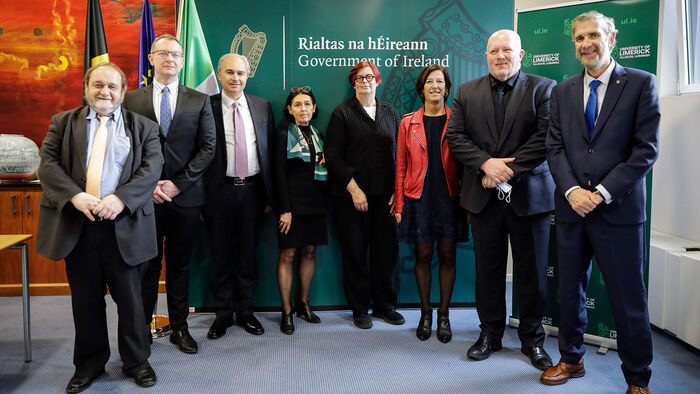 Eight university rectors standing next to one another wearing formal attire.