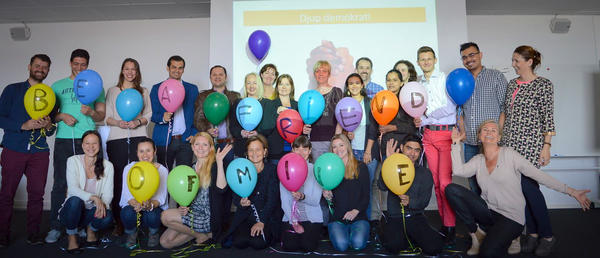Bilde av en rekke med folk som holder fargerike ballonger