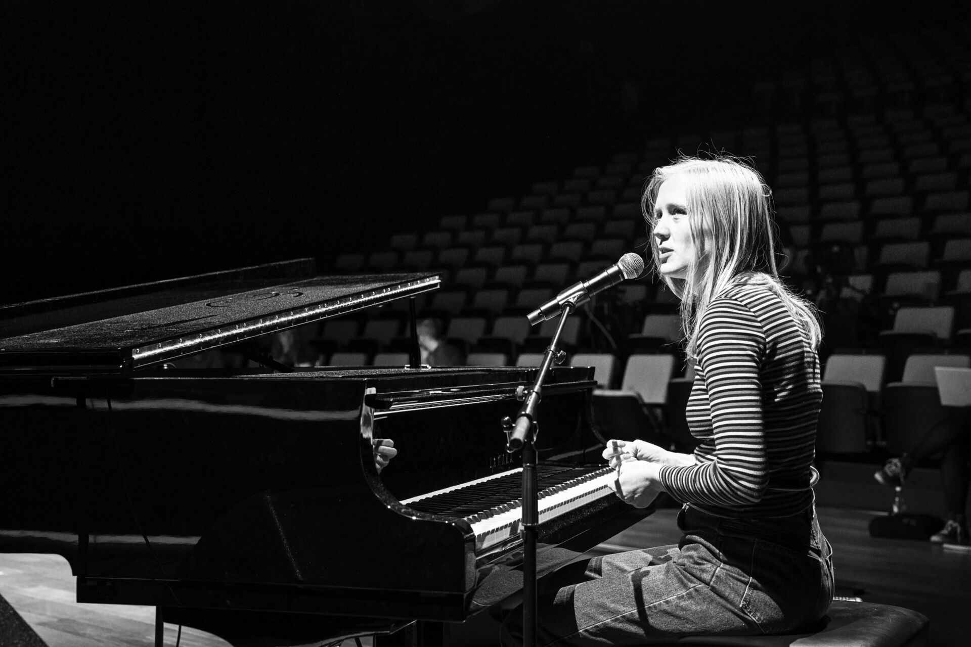 Ingunn sitter ved pianoet for å øve, litt bustete på håret.