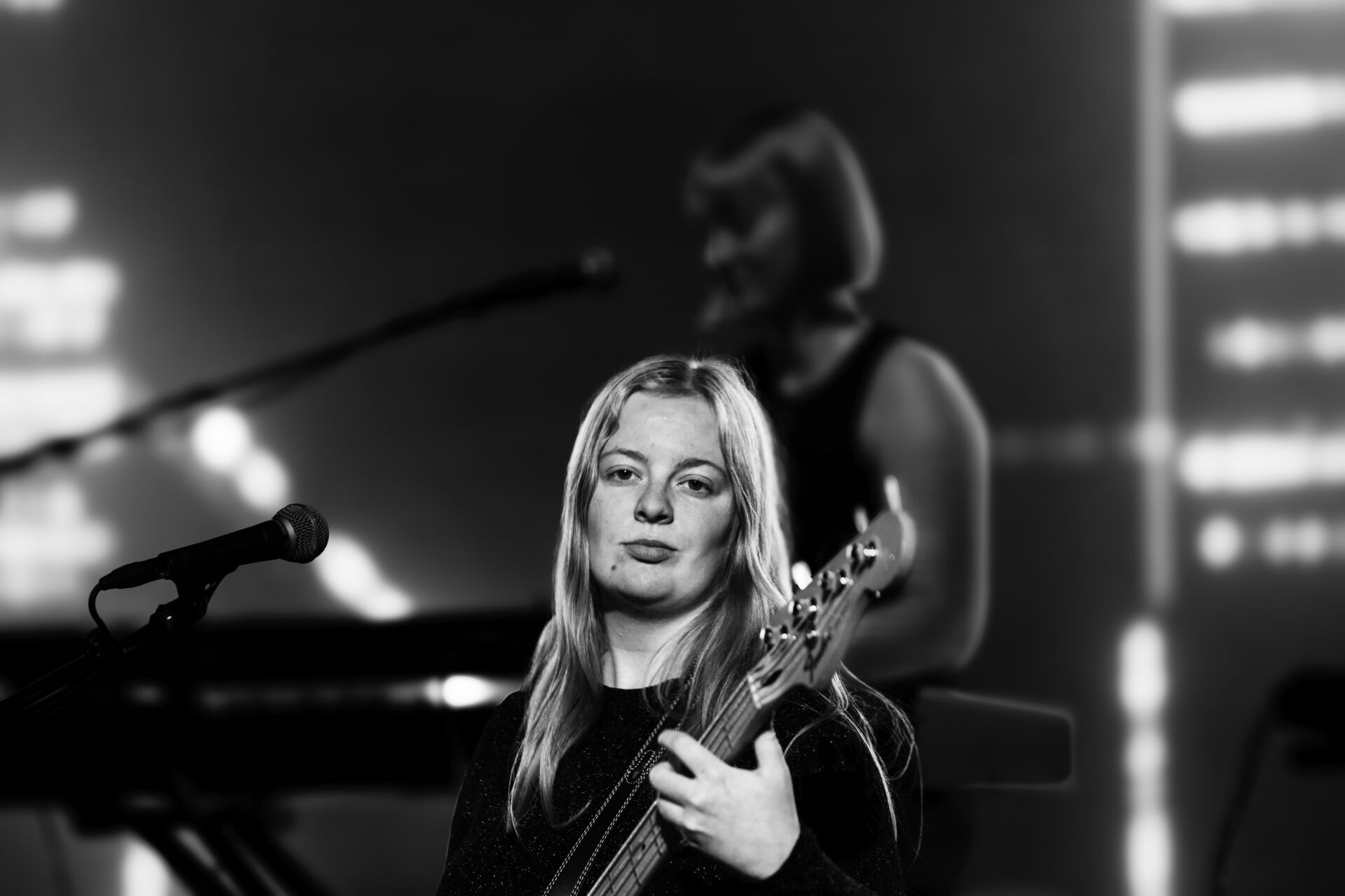 Kvinnelig student med gitar ser i kamera.