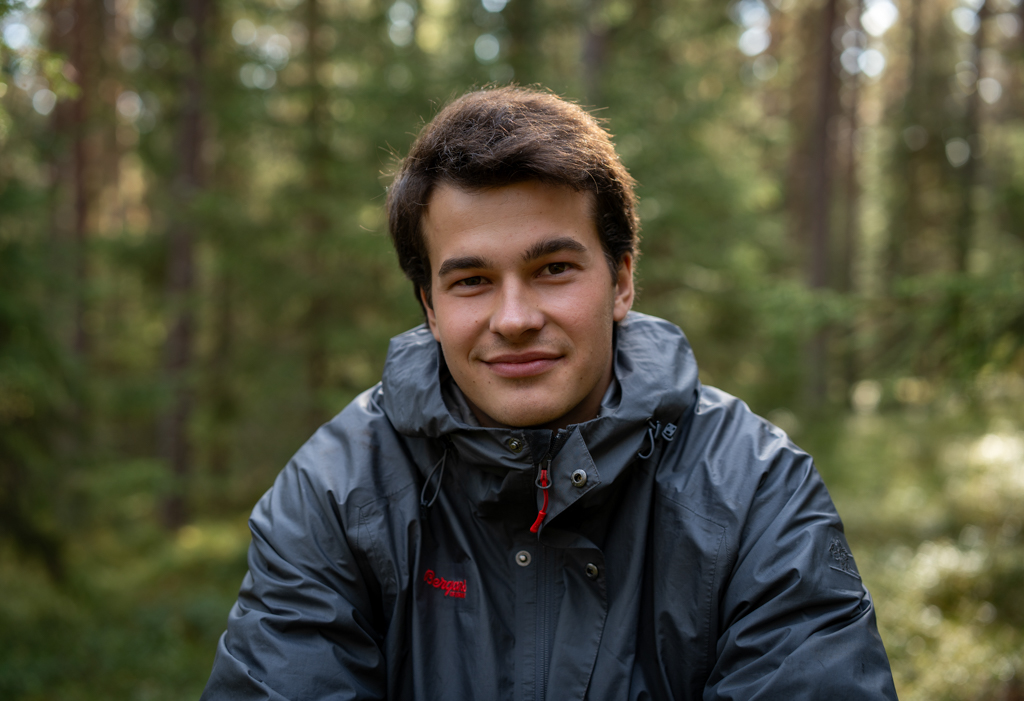 Portrait of  Oliver in the forest. He is smiling