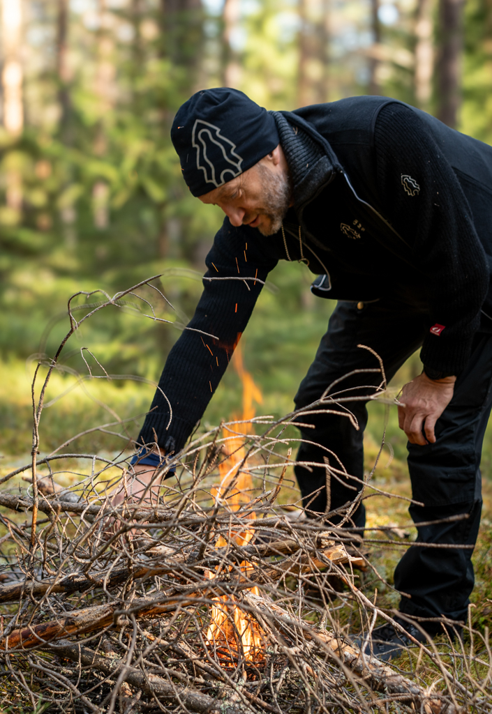 Lecturer Petter is lighting a fire before lunch