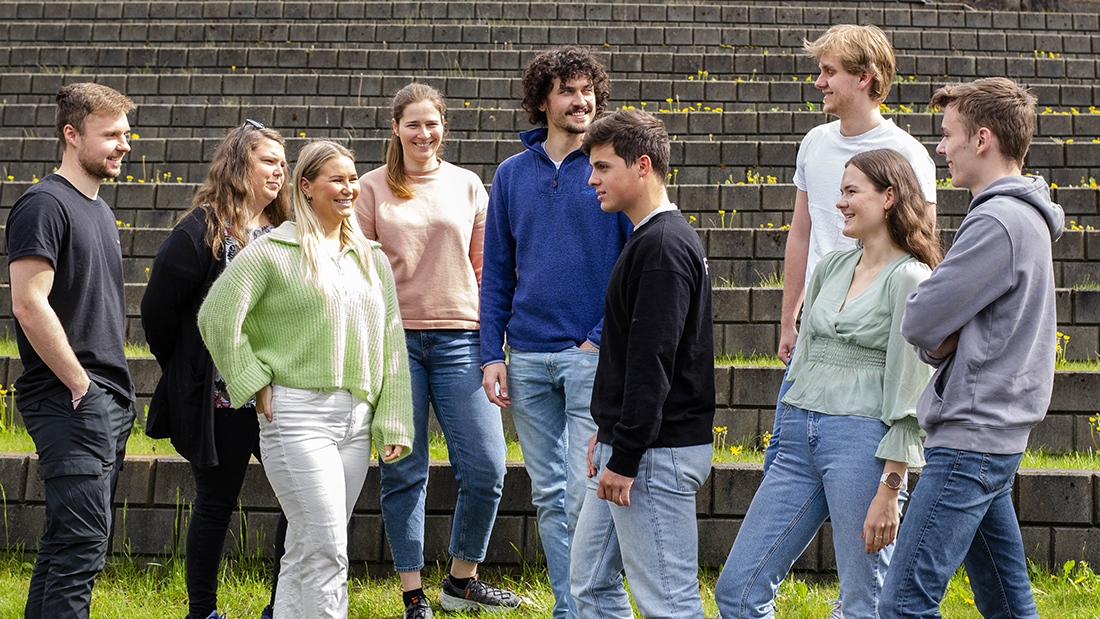 A smiling group of students standing on campus