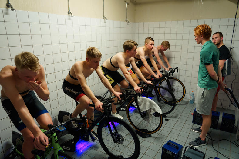 Mange syklister sykler på ergometersykkel i dusj