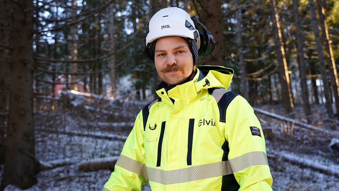Mann i gullt antrekk med hjelm på hode som arbeider i skogen.
