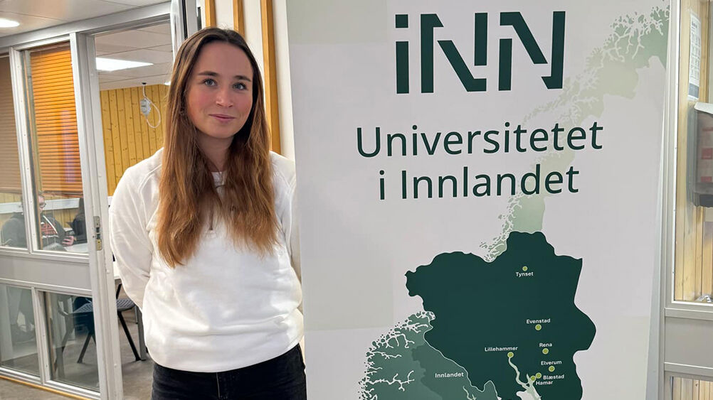 Kvinne i hvit genser ved siden av en rollup