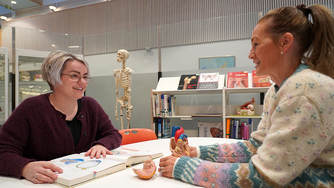 To kvinnelige sykepleiestudenter på biblioteket.