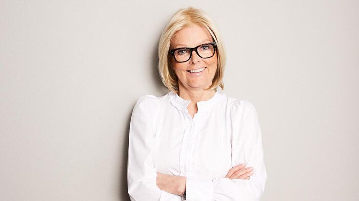 Portrettfoto av Nina Riibe mot en hvit bakgrunn. 