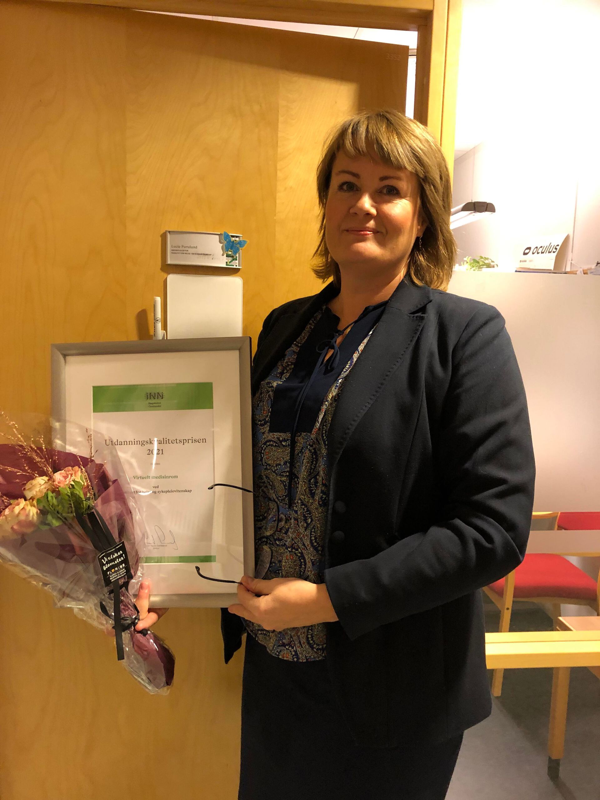 Bilde av Lucie som holder et diplom for Utdanningskvalitetsprisen 2021.