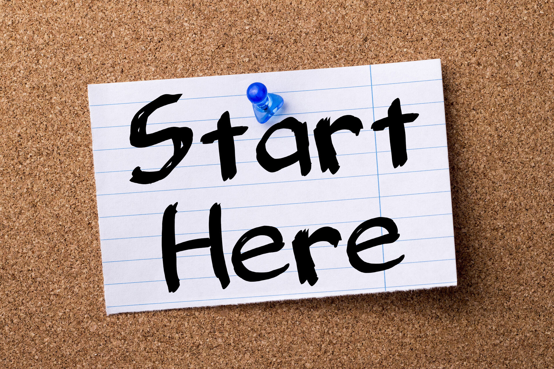 Start Here - teared note paper pinned on bulletin board