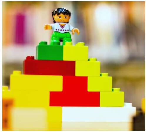 legofigur på toppen av en pyramide bygd av legobrikker