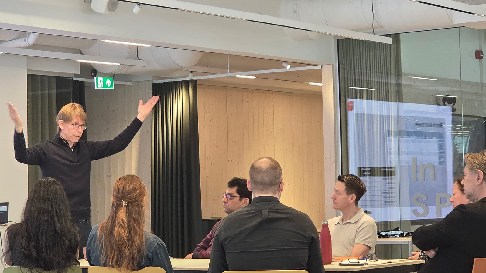 Lars Gillund står ved konferansebord og holder innløegg