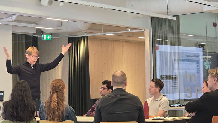 Lars Gillund står ved konferansebord og holder innløegg