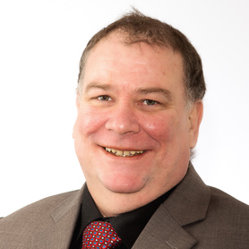 A portrait picture of Professor Harry P. Andreassen, where he is smiling.