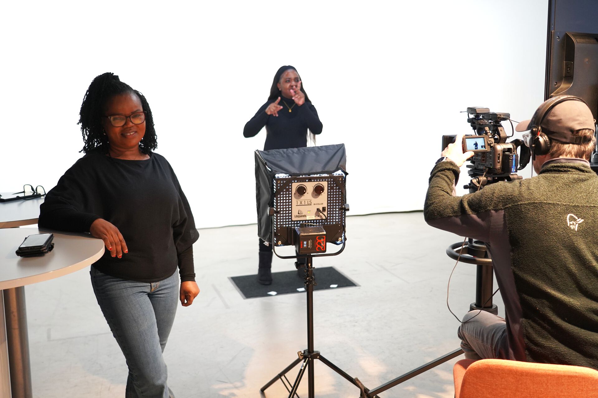 Two students are in a recording studio with a videographer