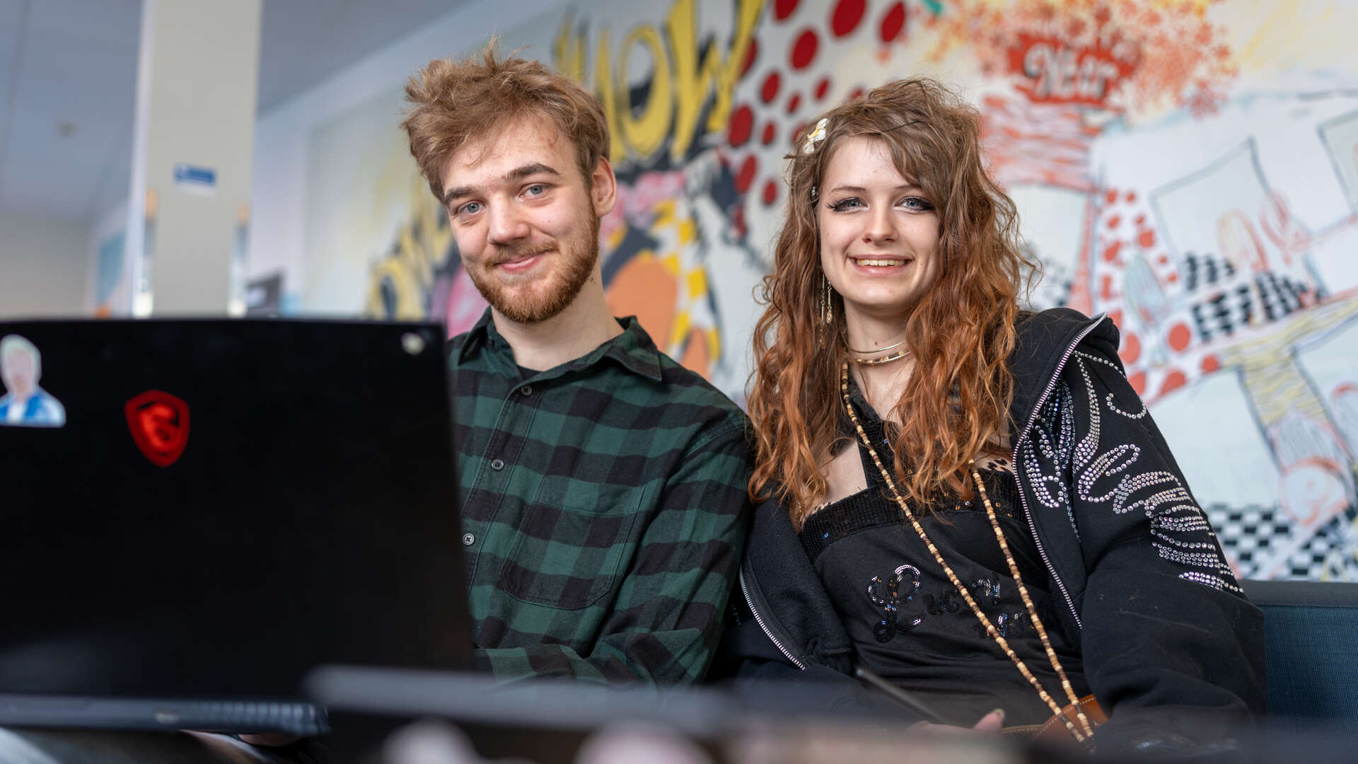 Two students are smiling at the camera
