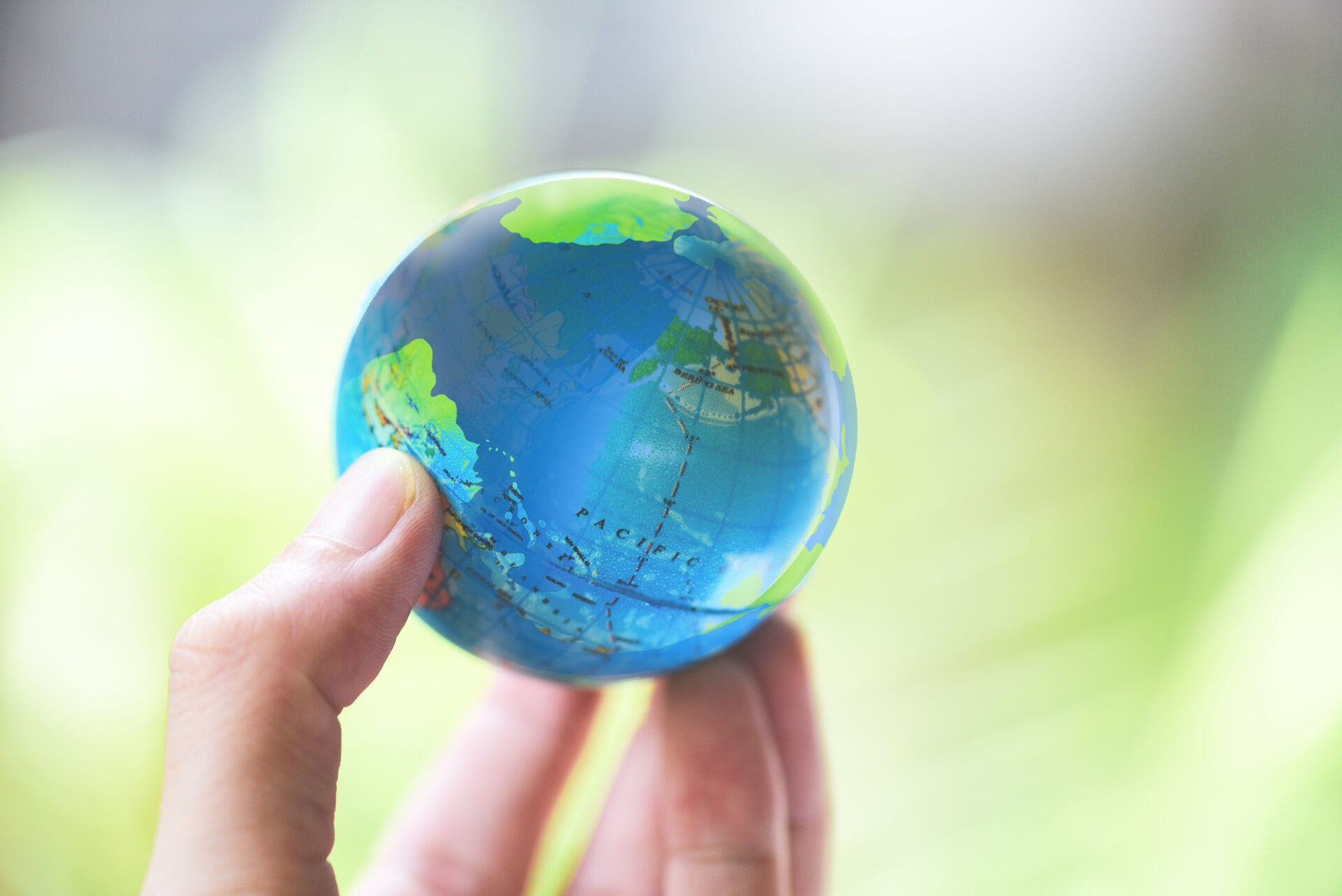 A hand is holding a globe