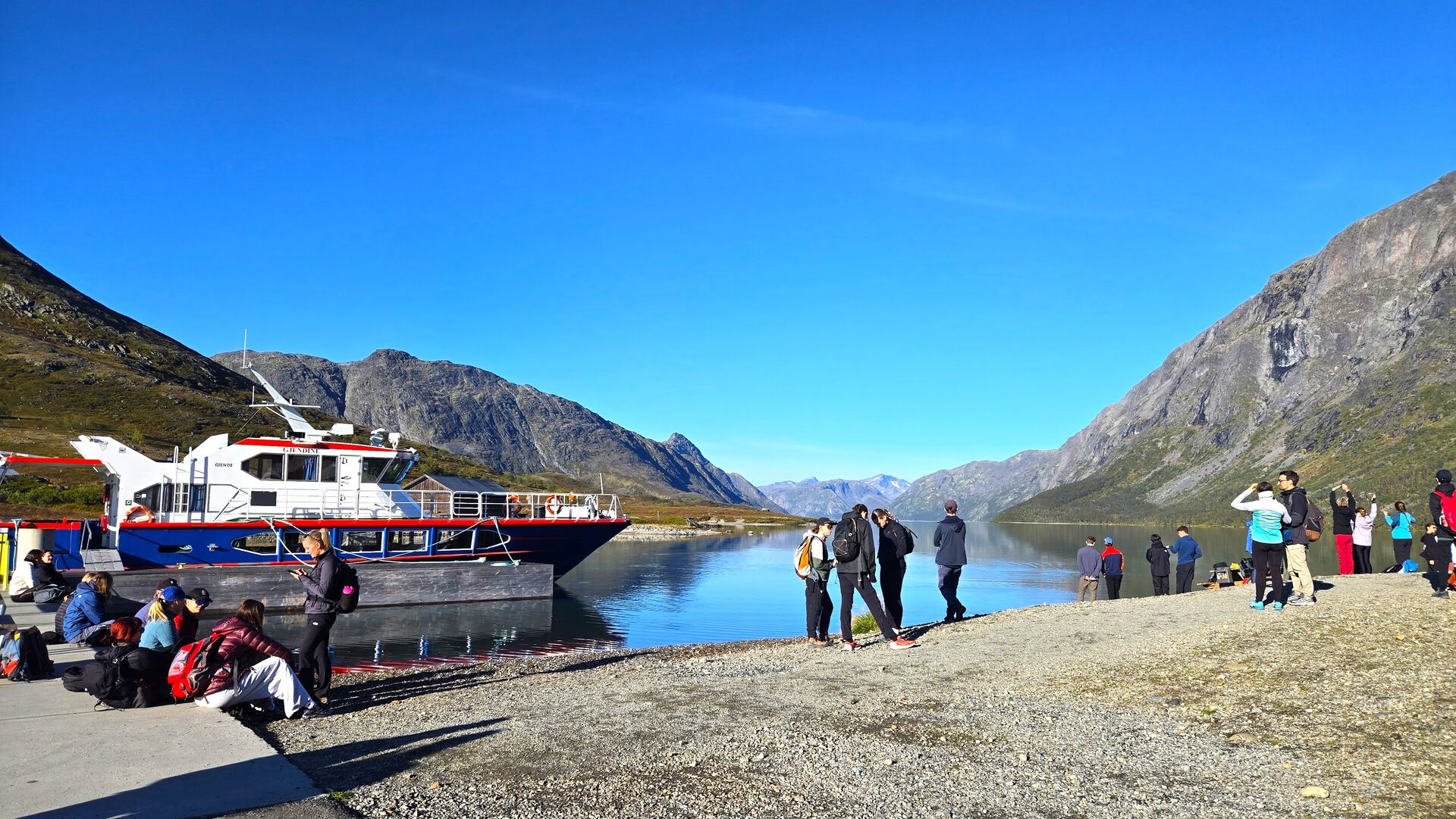 Students in front of a boat on a lake
