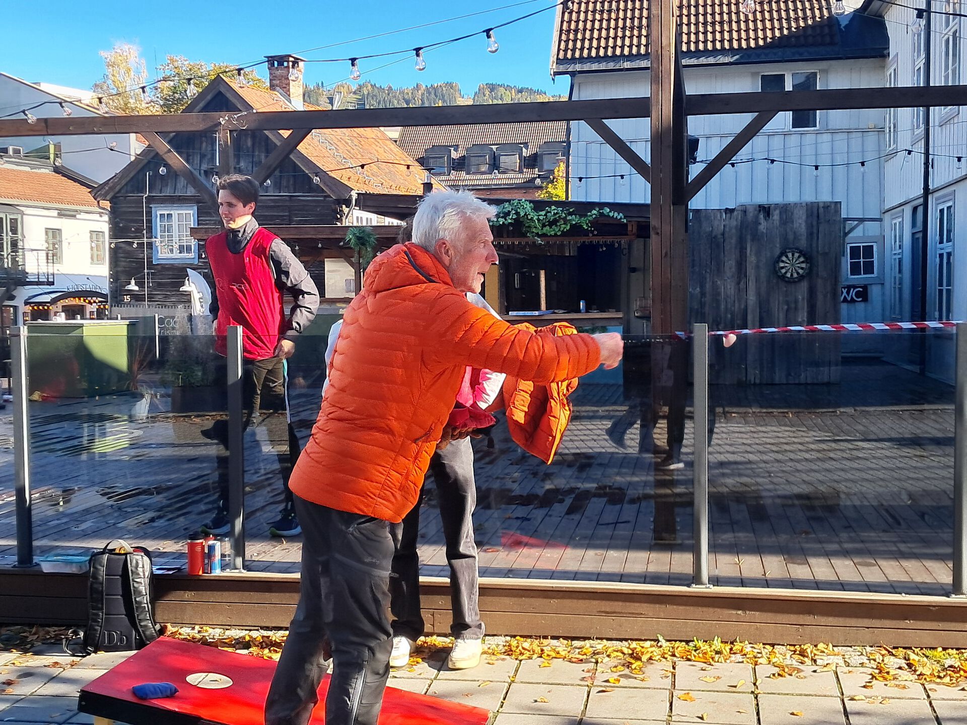 En eldre mann står ute og kaster noe i en idrett.