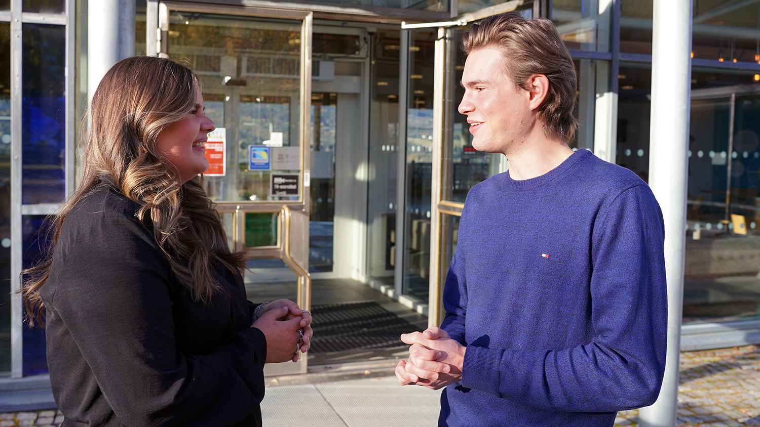 Esmee and Joel are talking and smiling outside of Lillehammer campus
