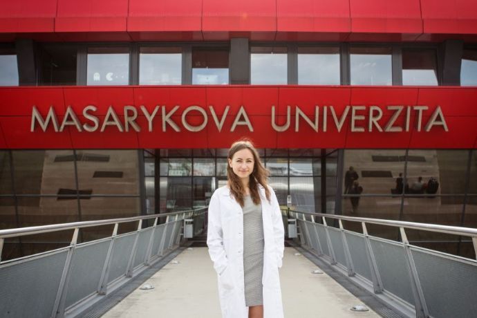 A student in front of the entrance to one of the faculties