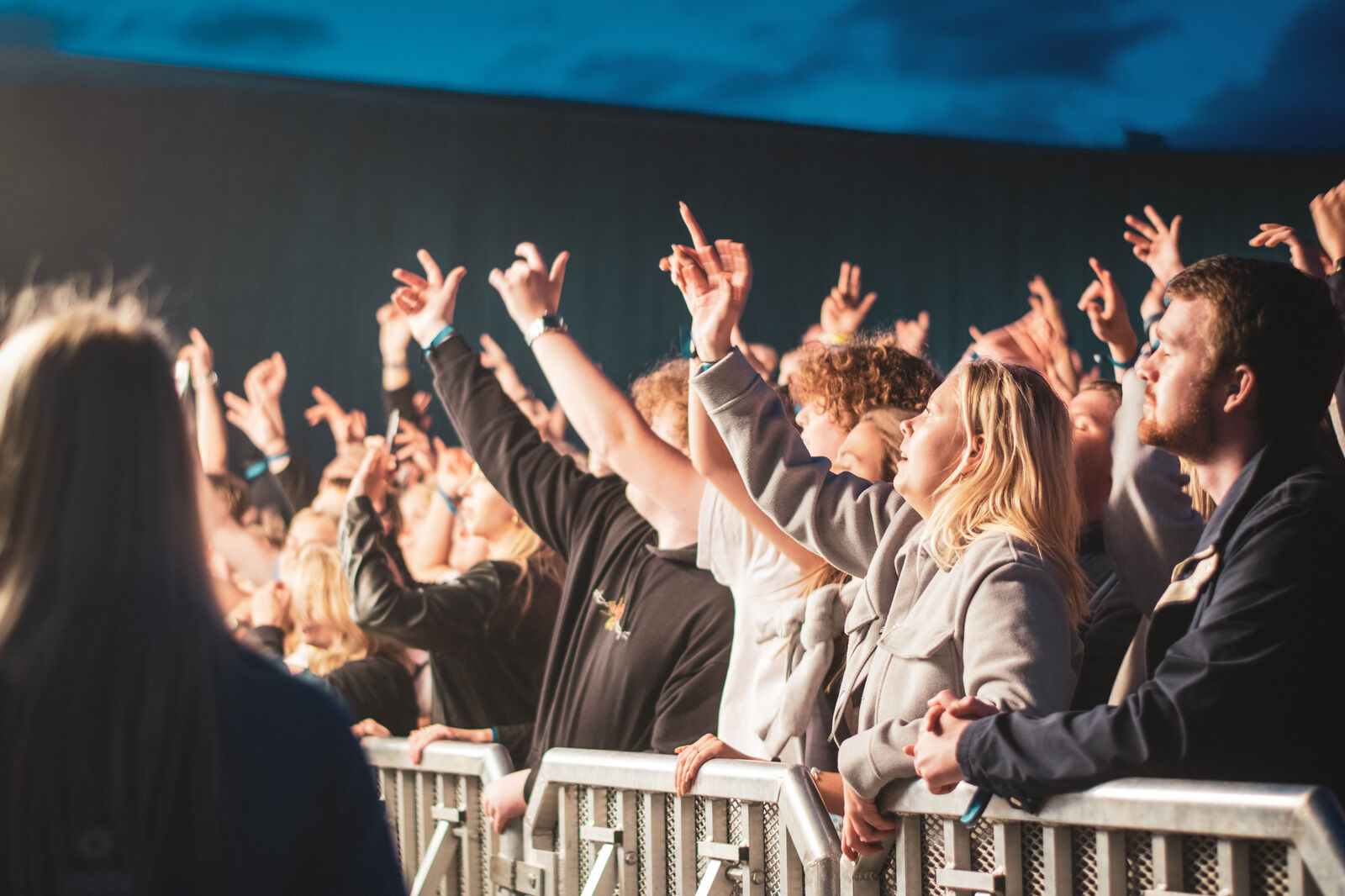 A student crowd is cheering at a concert