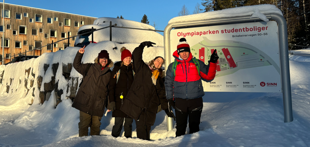 Exchange students posing happily during winter in front of a SINN dorm sign