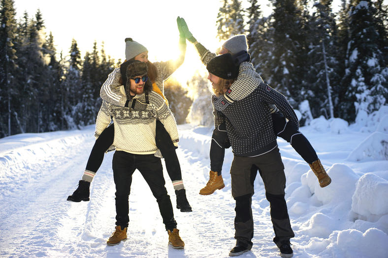 Two students piggybacking on a snowy road