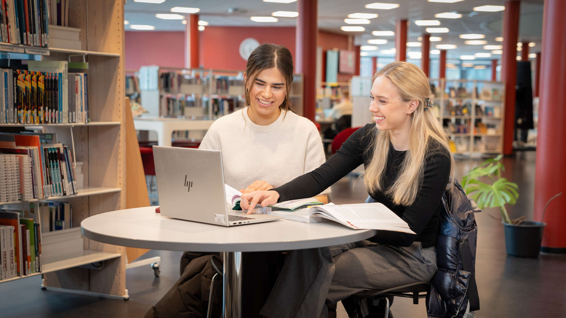 Two female students collaborating on a PC.