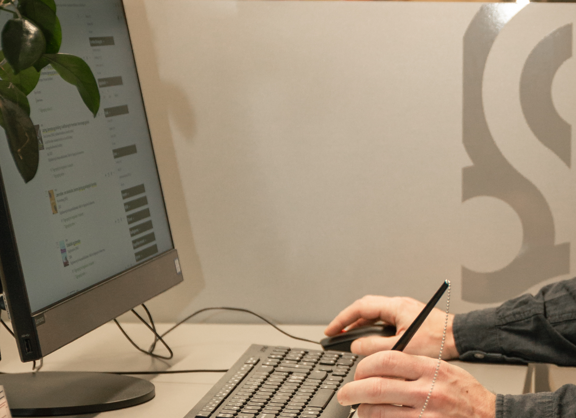 Hands on a keyboard with a PC screen to the right