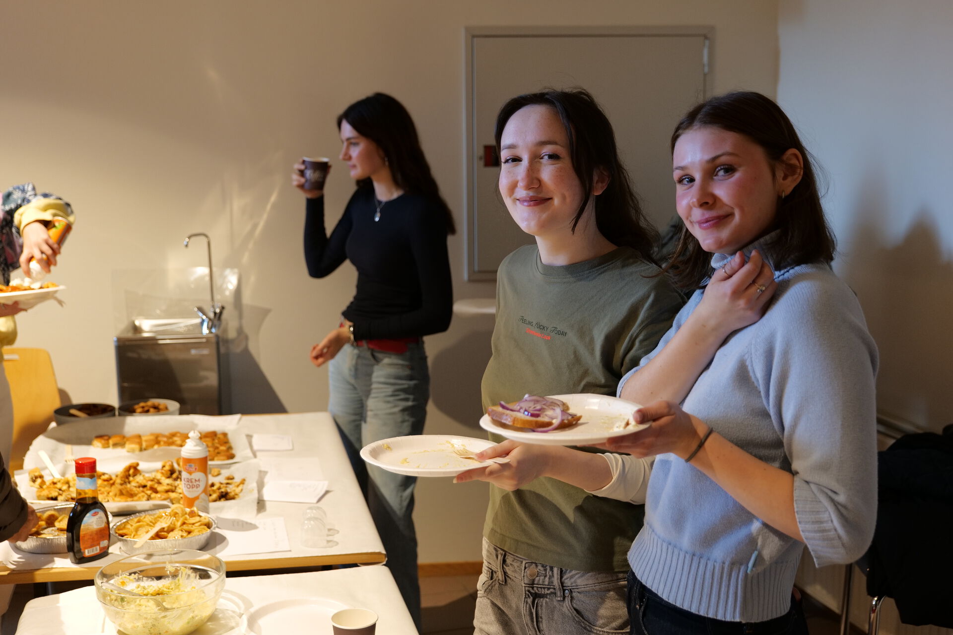 Three girls are smiling by food stands