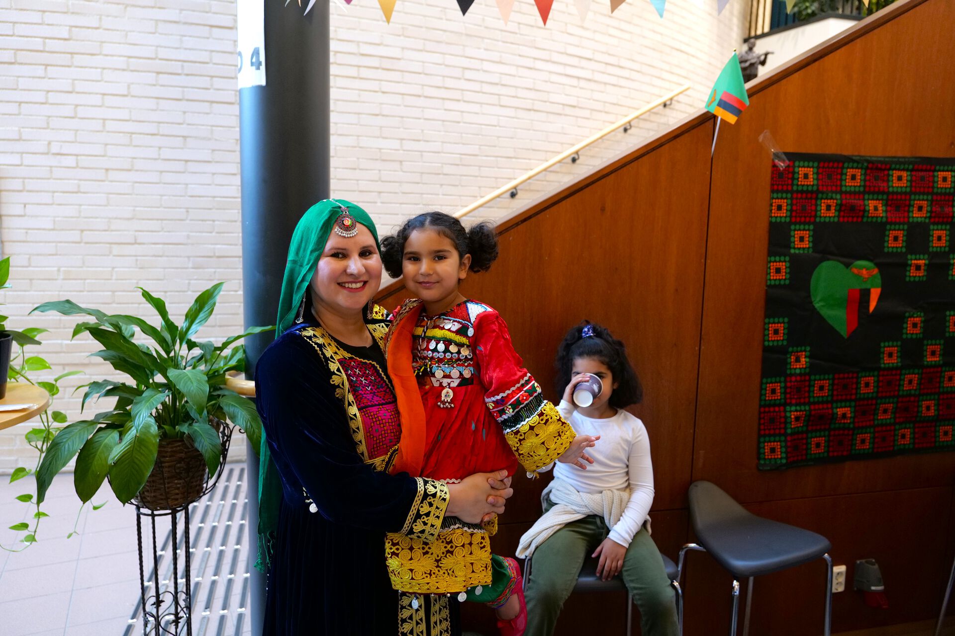 An Afghani mother and daughter are smiling in coloutful clothing