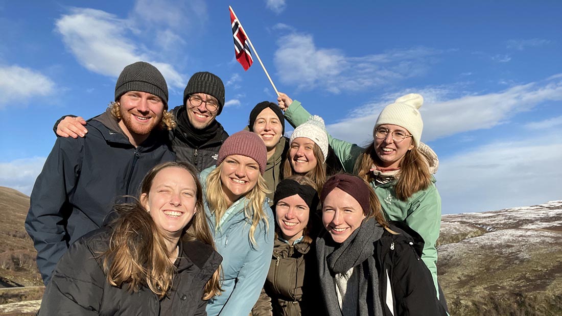 A group of international students with a Norwegian flag. 