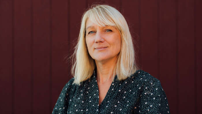 Woman with blonde hair and dark blouse