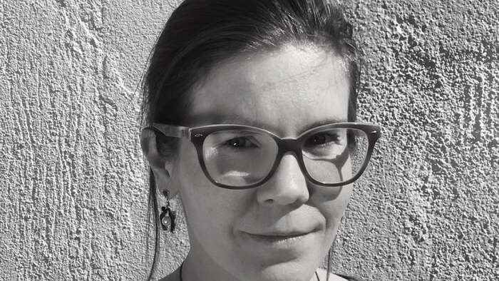 Black and white photo of woman with dark hair and glasses