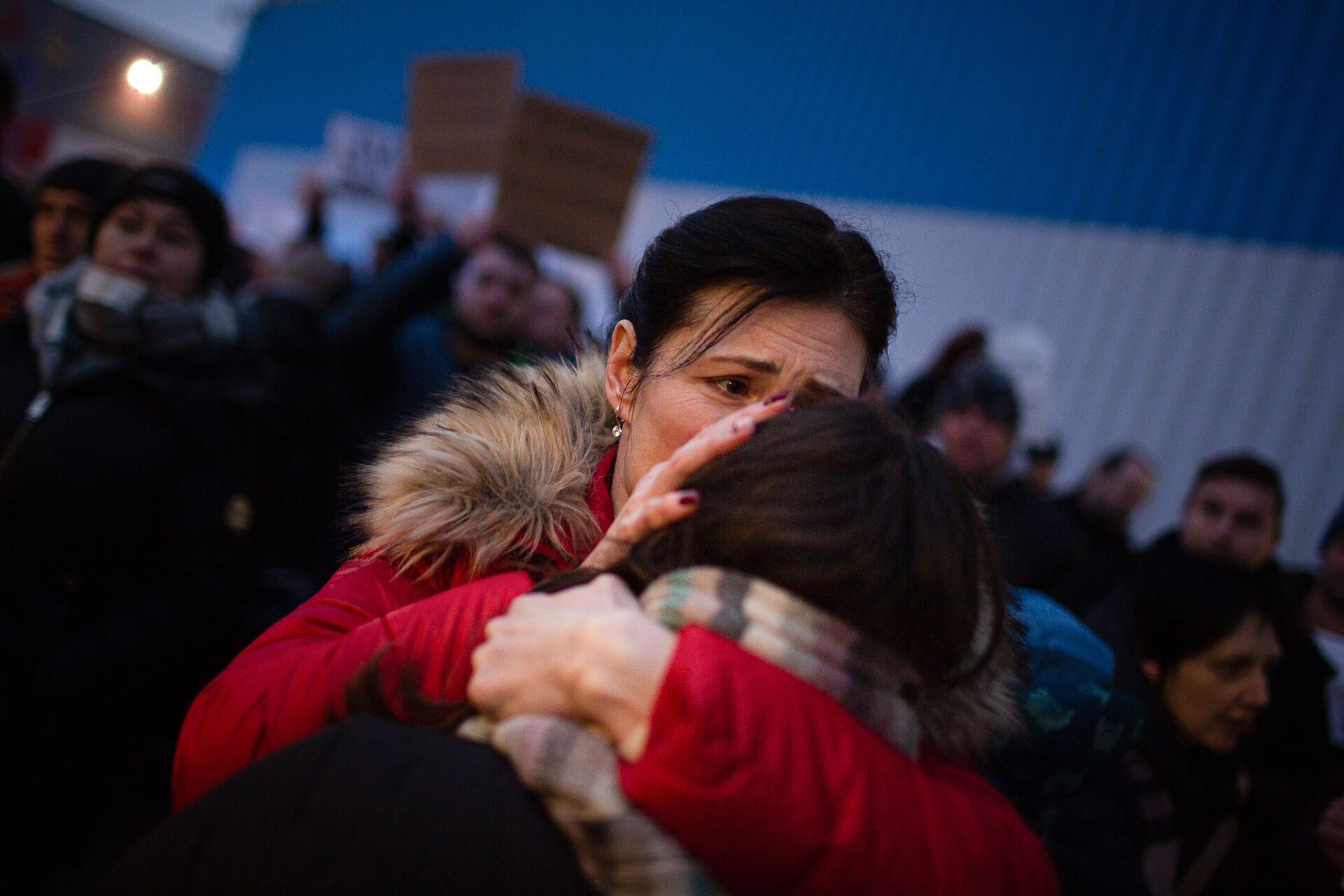 A sad woman hugging a child.