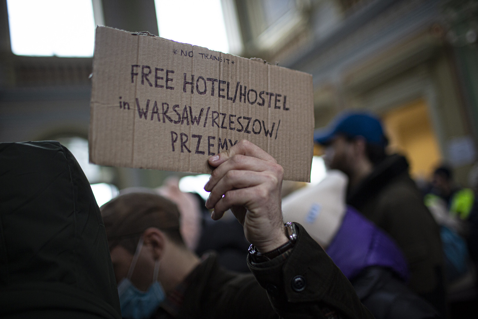 A hand holding a sign that reads 