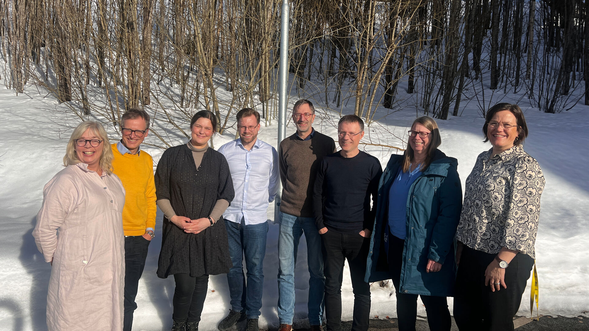 8 people in front of trees and snow