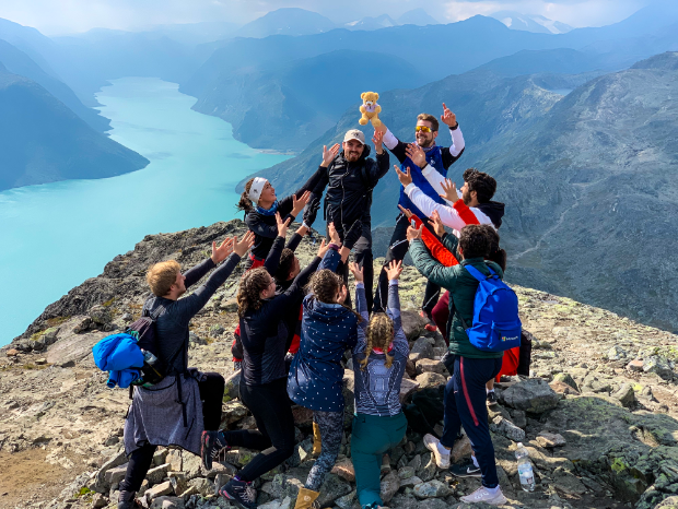 A group of students standing on top of a mountain
