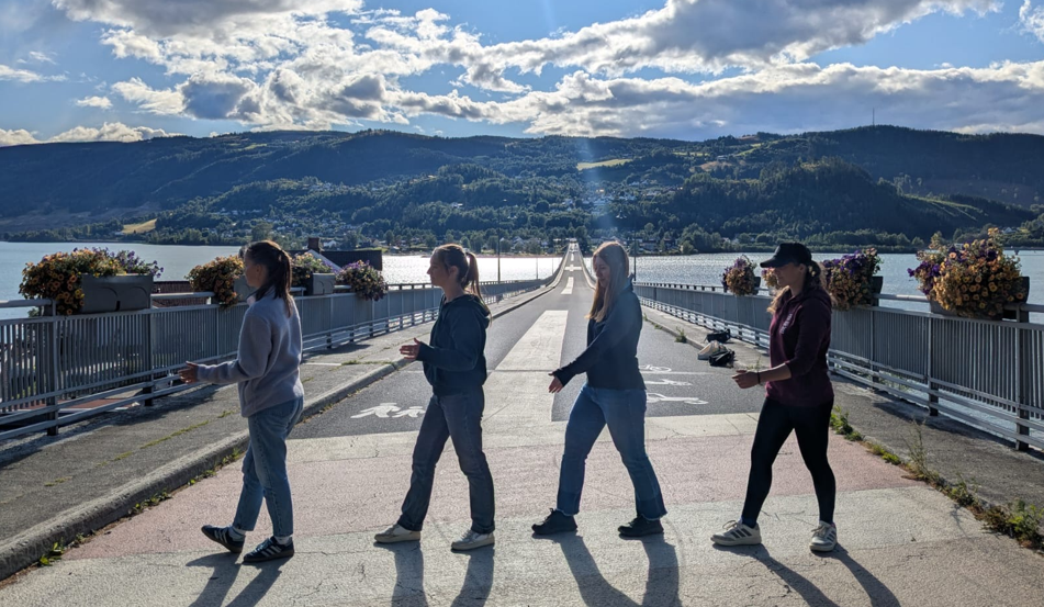 Female exchange students walking in a row on a bridge on a late autumn sunny day.