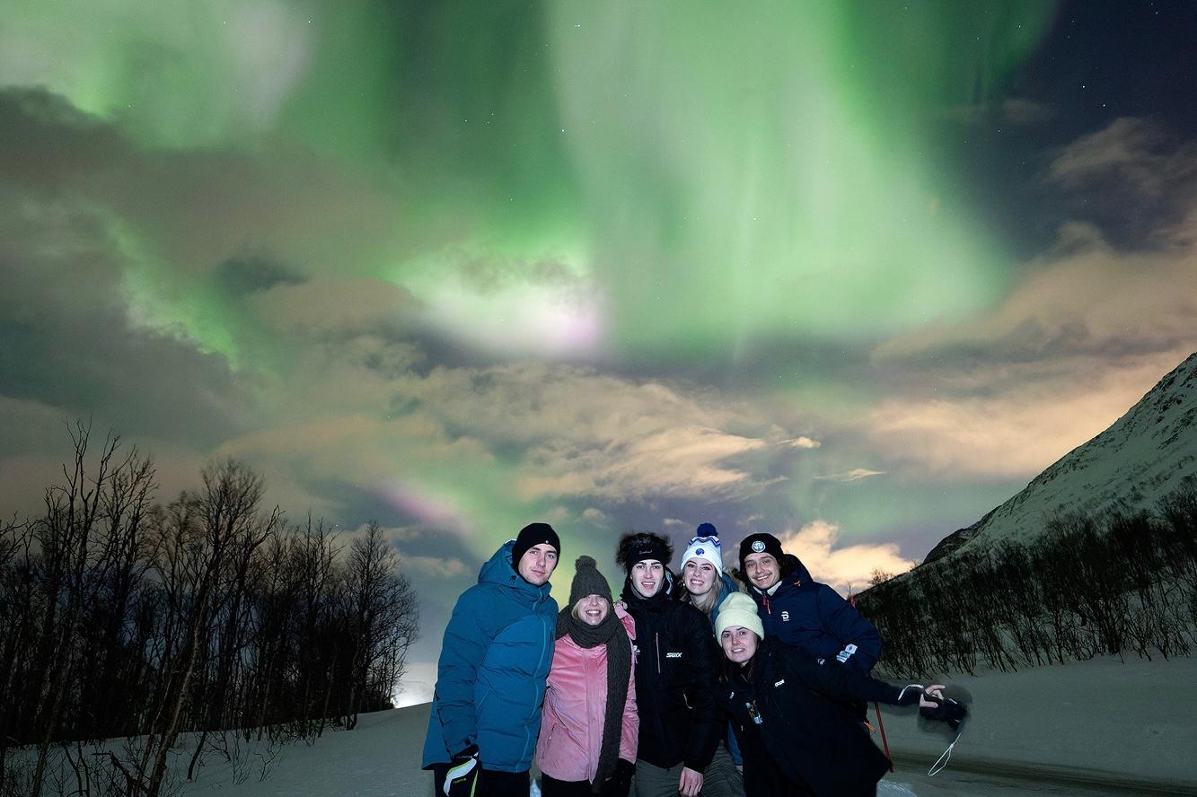 Exchange students experiencing the bright northern lights on the sky during winter