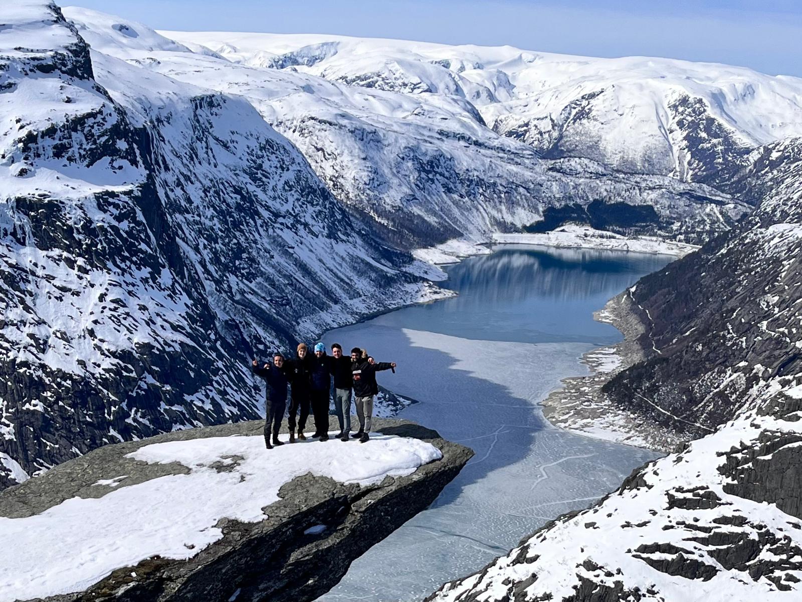 Exchange students standing on the viewpoint of Trolltunga, Stavanger in the snow covered mountains