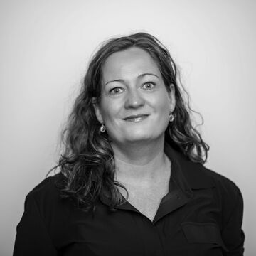 Svart hvitt portrettbilde av en smilende Heidi Linde.