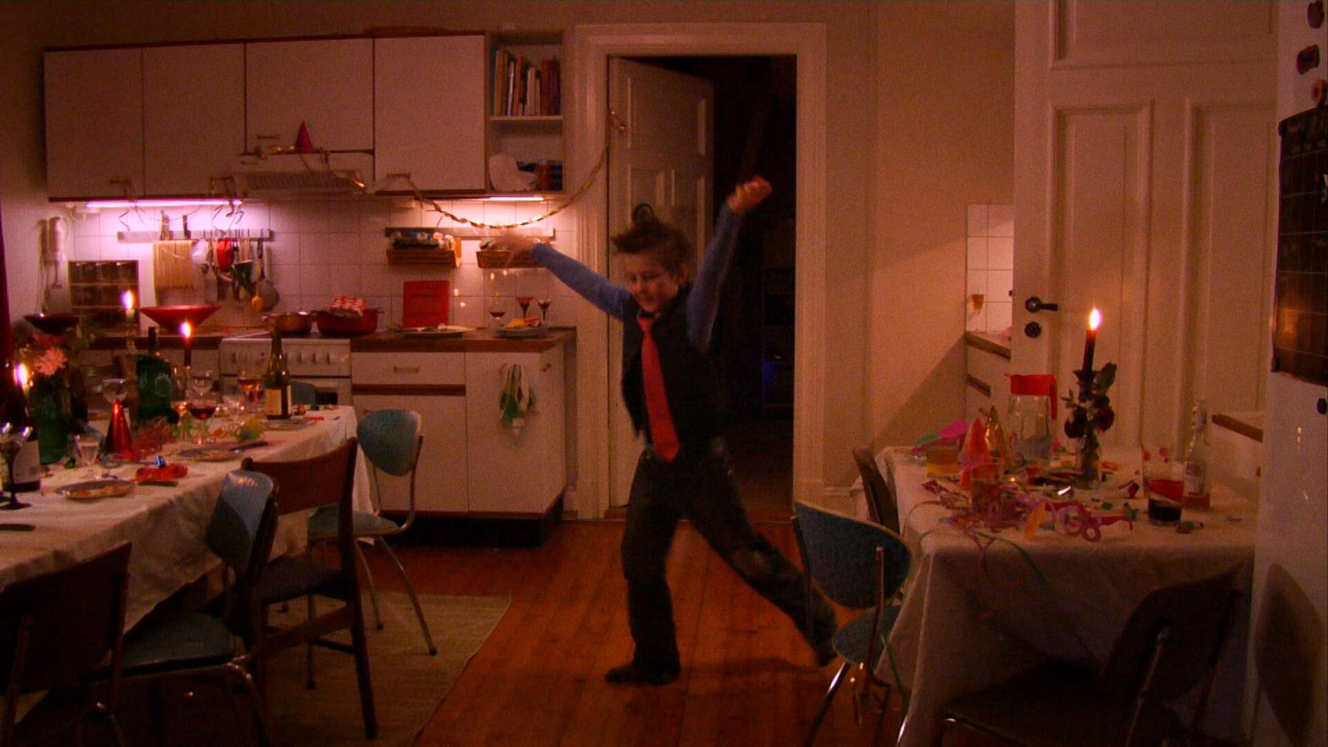 En gutt danser i et rom der det har vært fest