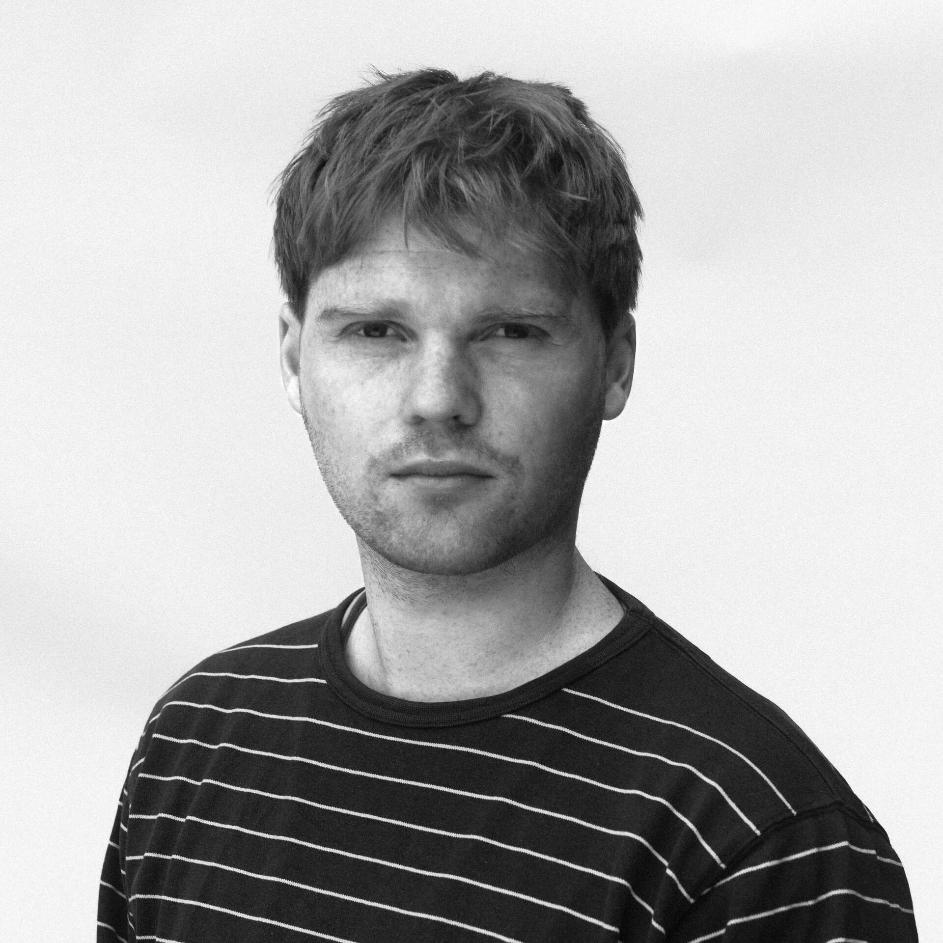 Portrettbilde av Eivind Lundby som ser alvorlig i kamera