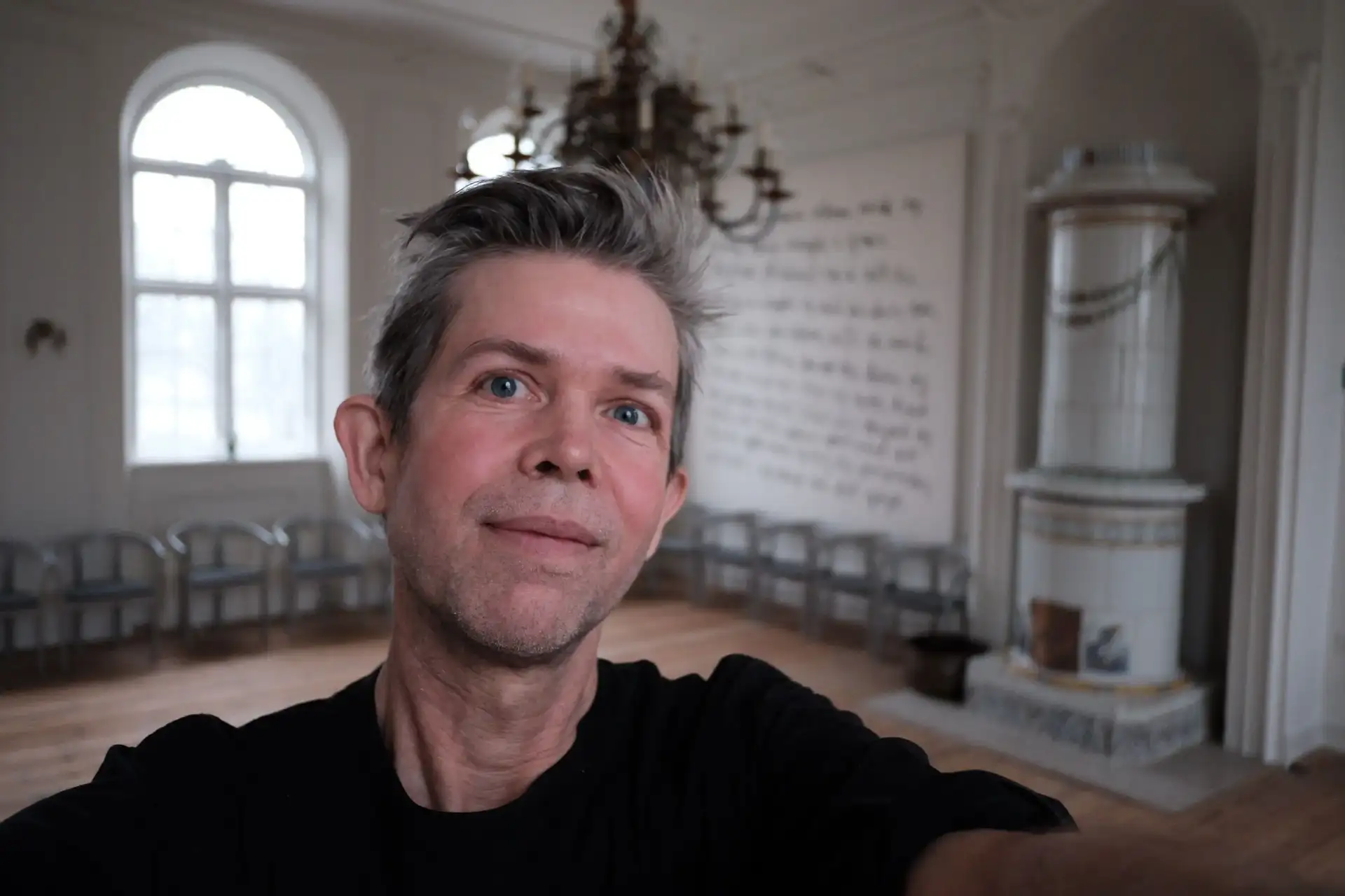 Simon Jon ser vennlig inn i kamera i en selfie tatt i et museumsrom