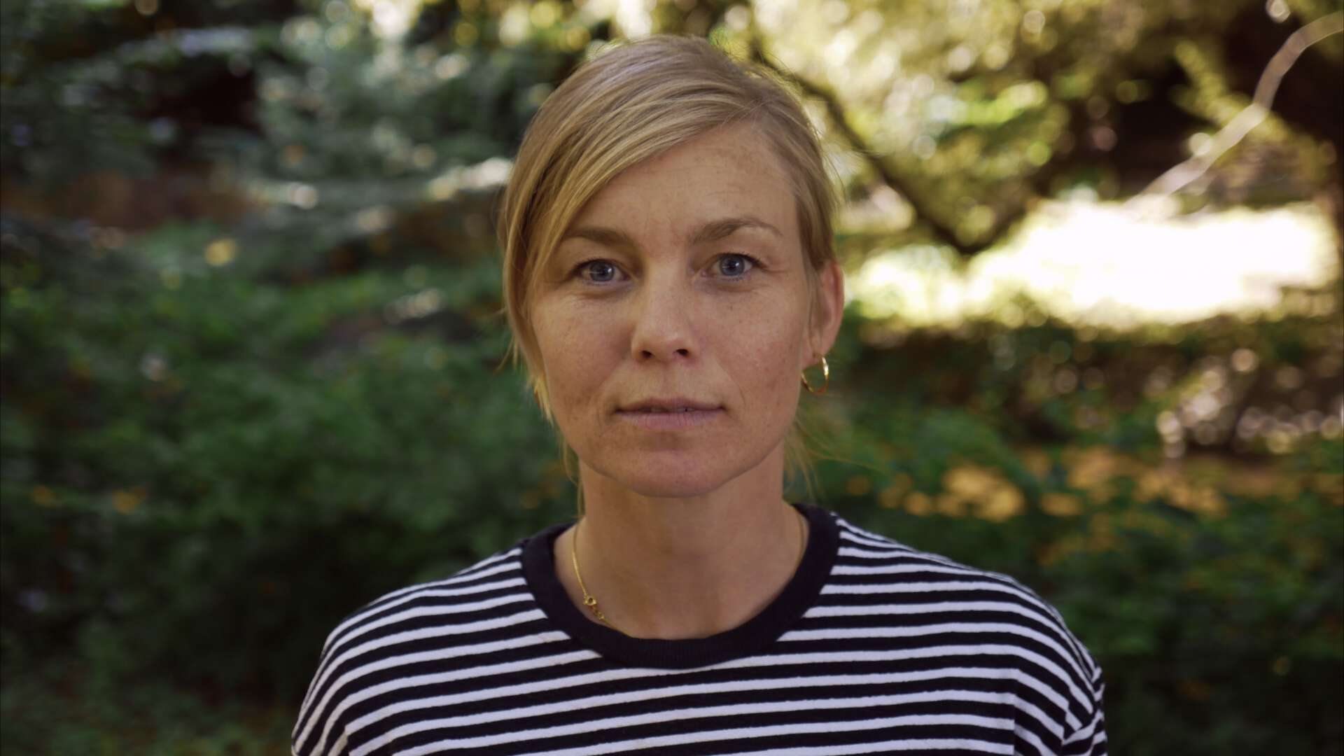 Portrettbilde av Aasne Vaa Greibrokk med natur i bakgrunnen.