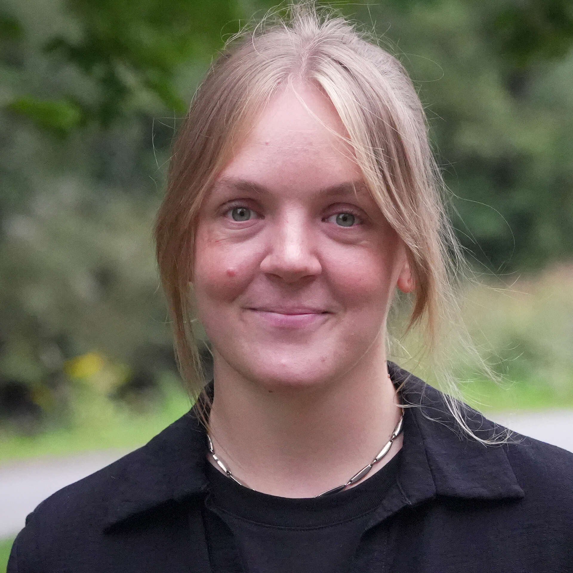 Portrettbilde av en smilende Tora Turøy som ser rett i kamera.